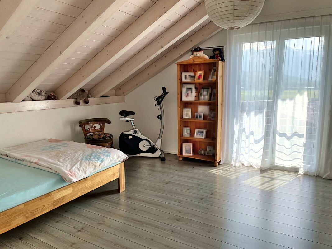 Dachzimmer mit Bett und Dachschrägen