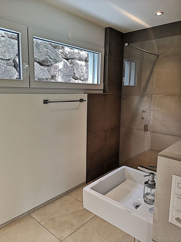 Modernes Bad mit bodengleicher Dusche und Fenster