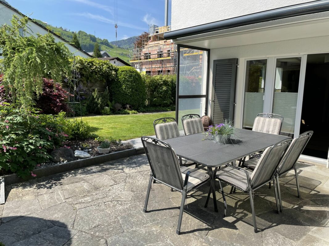 Terrasse mit Gartenmöbeln und Blick ins Grün