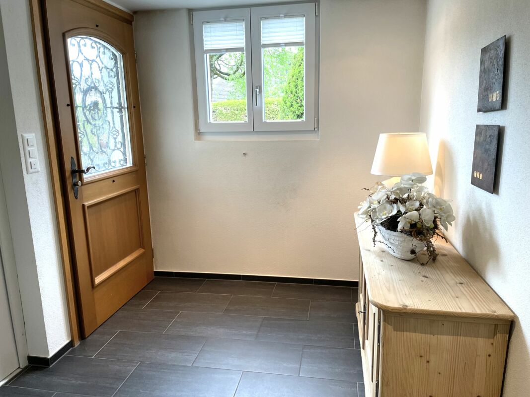 Heller Eingangsflur mit Holztür und Fenster