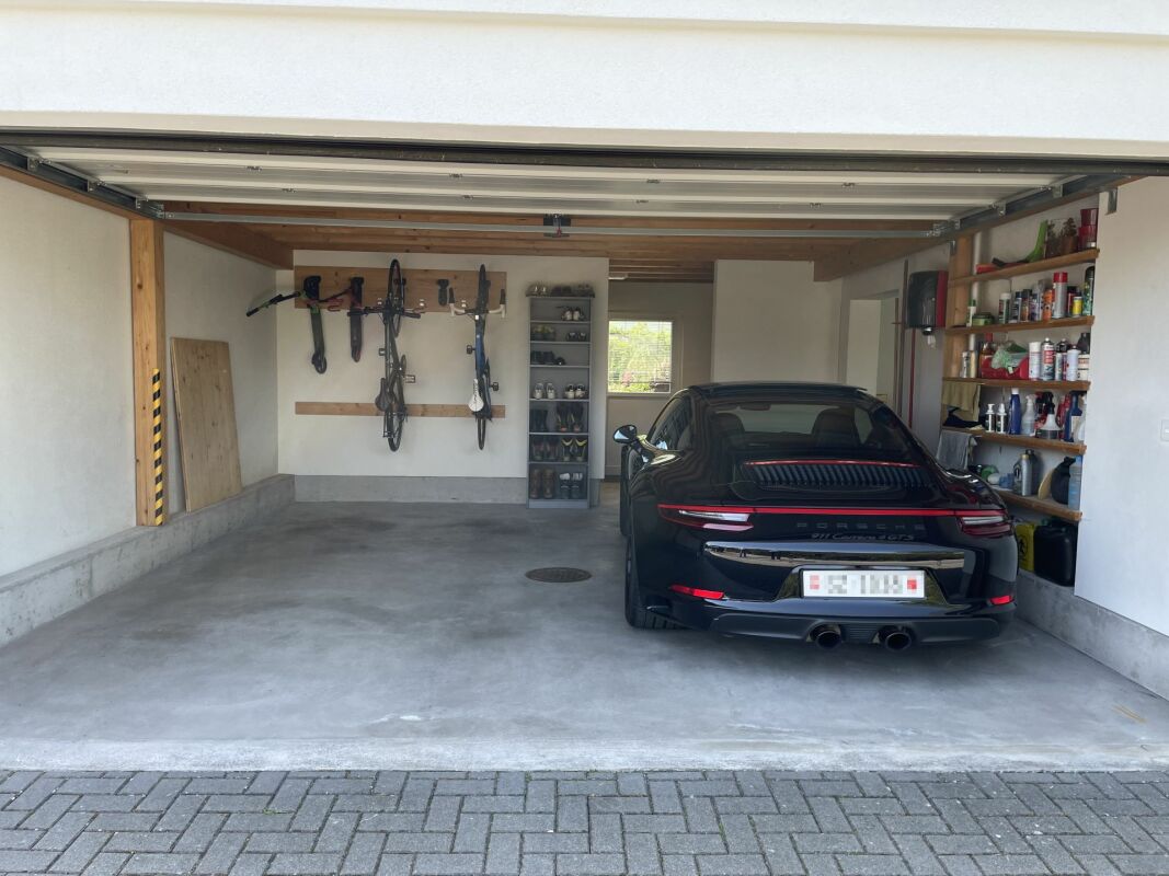 Garage mit geparktem Sportwagen und Regalsystem