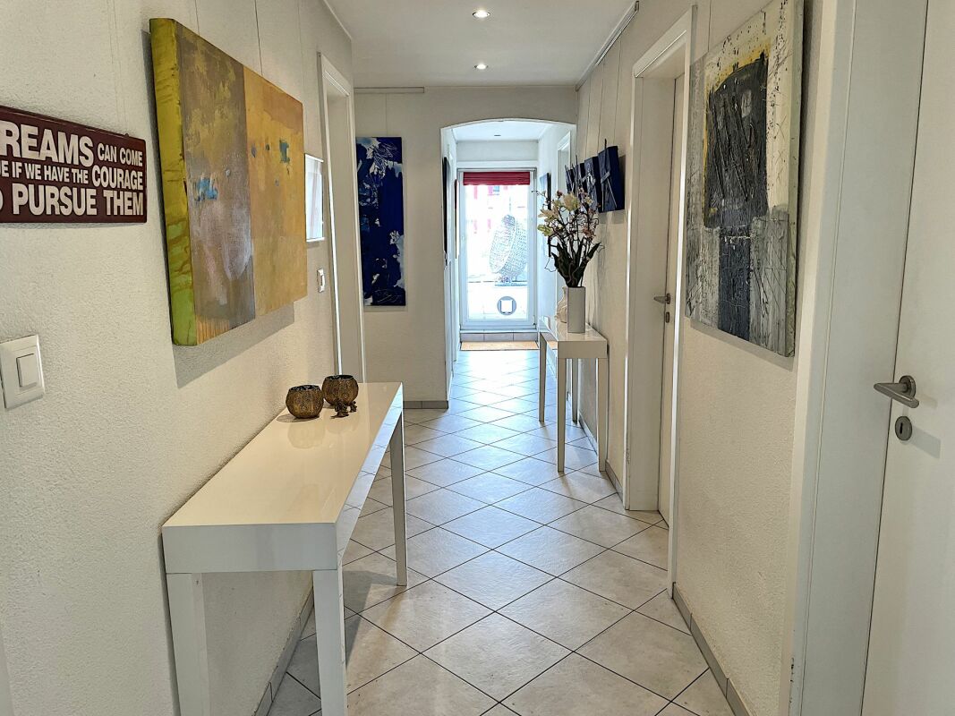 Heller Flur mit Kunst und Konsolentischen