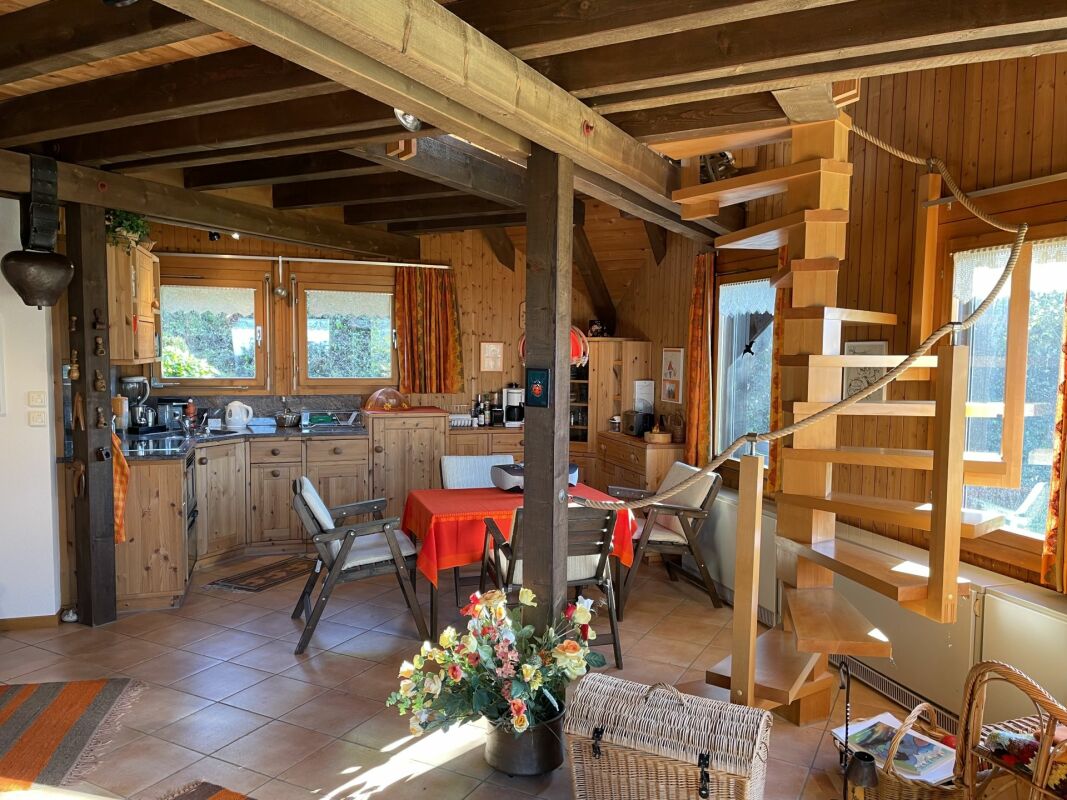 Gemütlicher Holz-Wohnraum mit Küche und Wendeltreppe