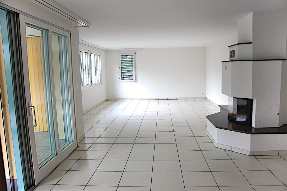 Heller Wohnraum mit Fliesenboden und Kamin