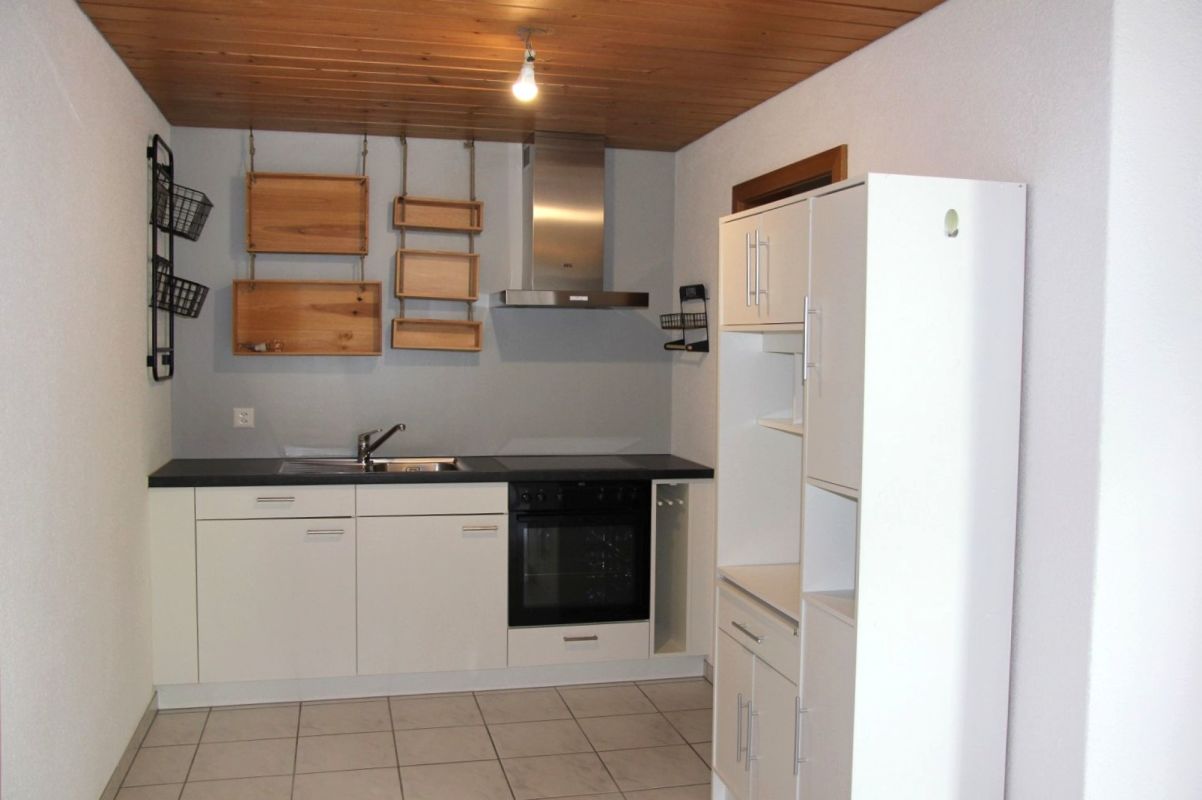 Kleine Küche mit Holzdecke und weißen Fronten