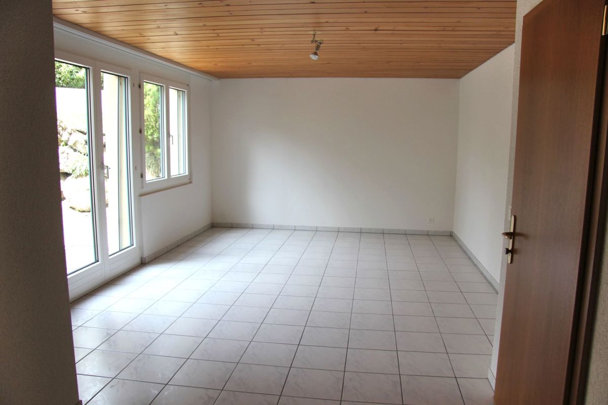 Leerer heller Raum mit Fliesenboden und Holzdecke