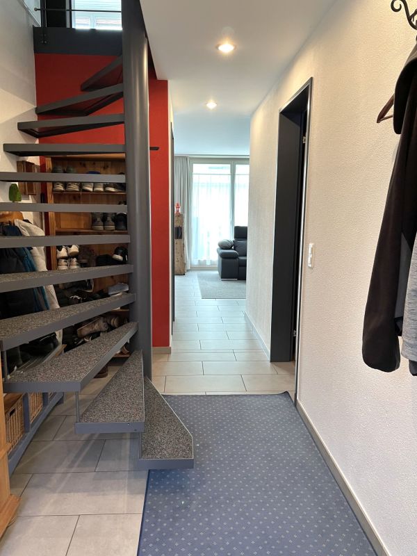 Flur mit offener Treppe und Blick ins Wohnzimmer