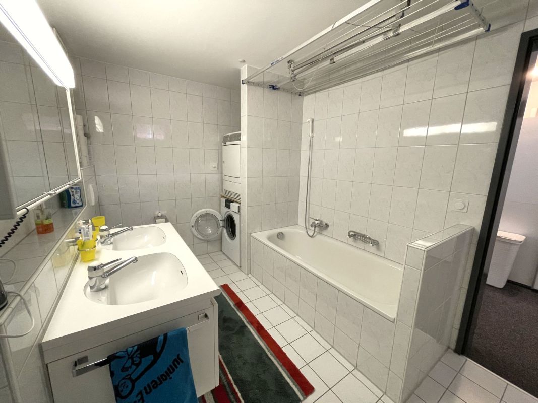 Badezimmer mit Doppelwaschtisch und Badewanne