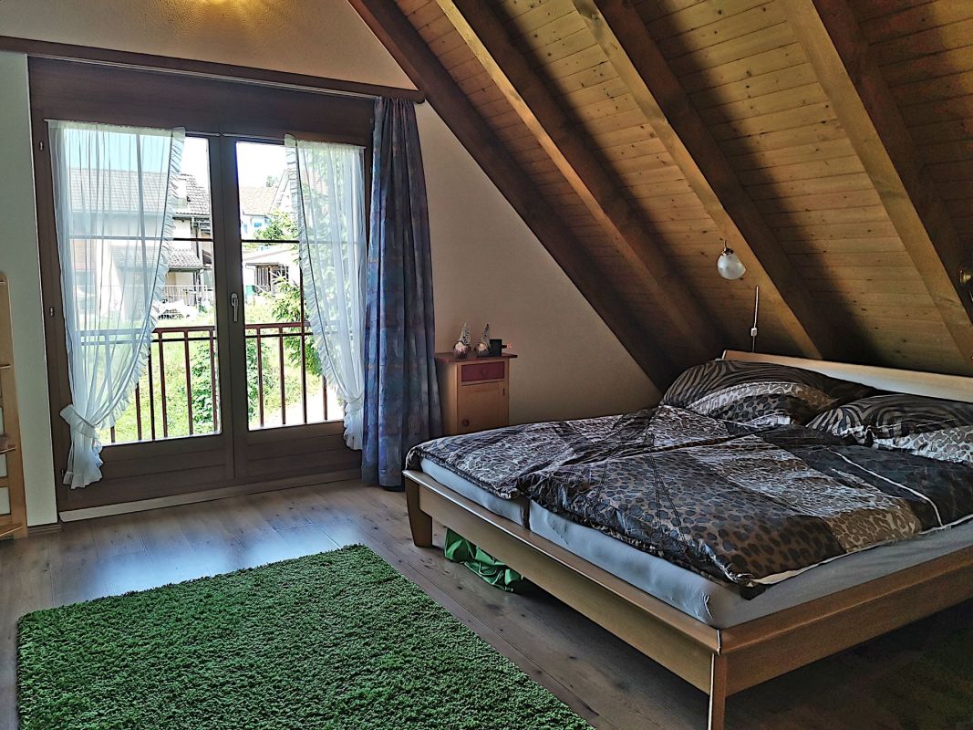 Dachgeschoss-Schlafzimmer mit Balkonblick