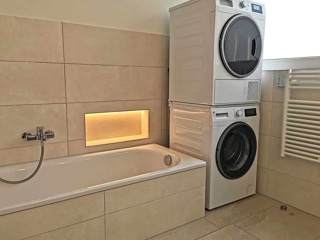 Modernes Badezimmer mit Wanne und Waschgeräteturm
