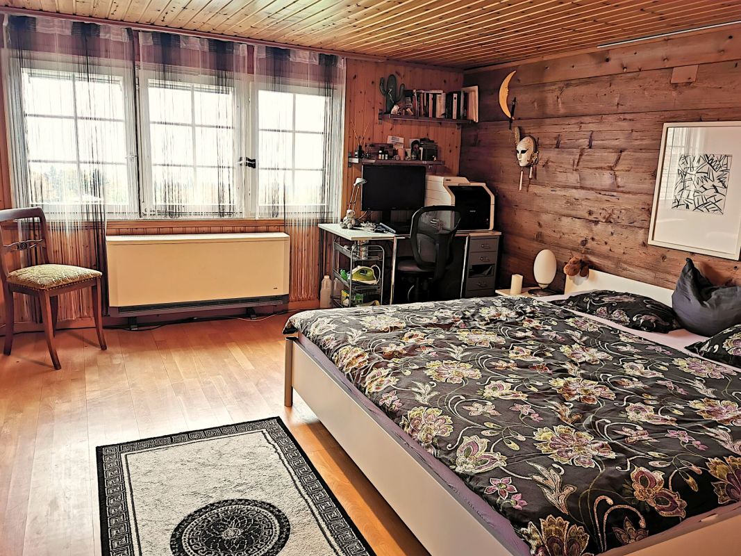 Rustikales Schlafzimmer mit Holzvertäfelung