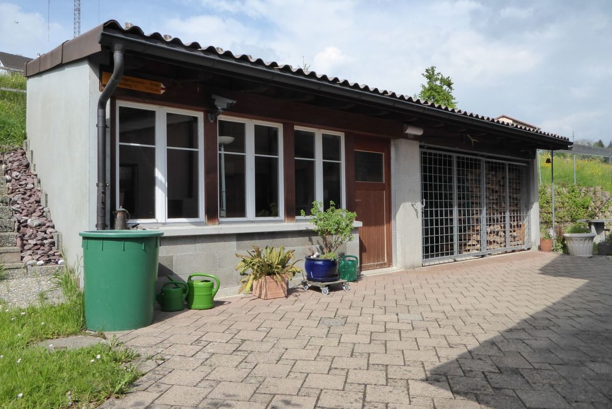 Außenansicht eines kleinen Nebengebäudes mit überdachter Fassade