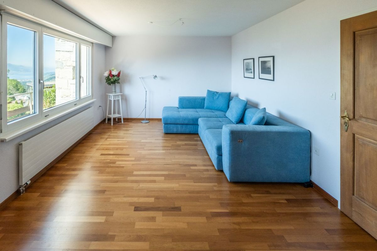 Wohnzimmer mit Sofa und Balkonblick