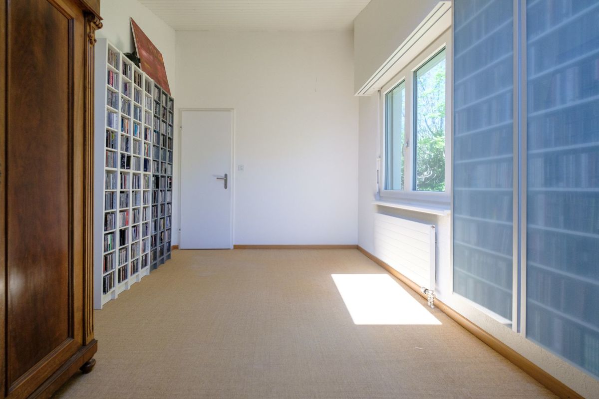 Helles Zimmer mit Fensterwand und CD-Regal