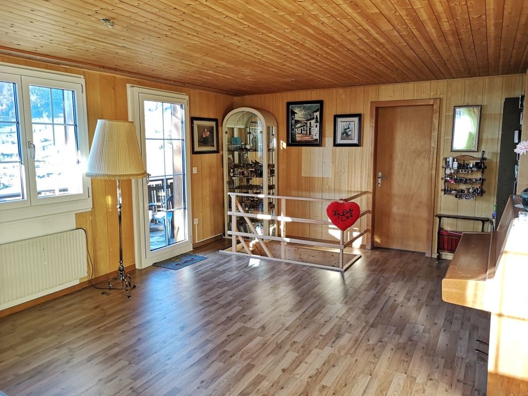 Holzvertäfelter Wohnraum mit Treppe und Balkonzugang