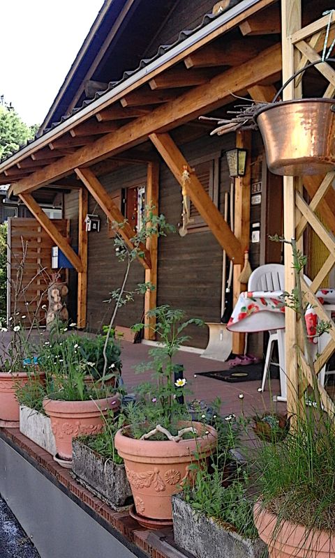Veranda mit Holzüberdachung und Pflanzkübeln