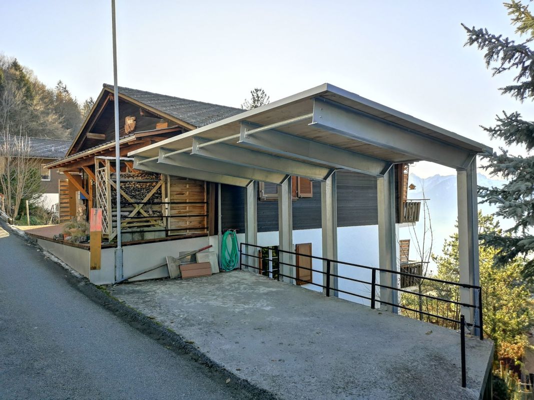 Außenansicht eines alpinen Hauses mit Carport