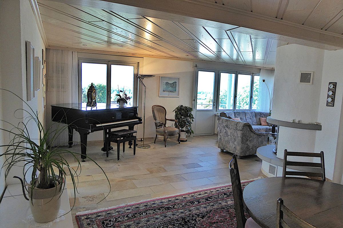 Heller Wohnraum mit Klavier und Panoramafenstern