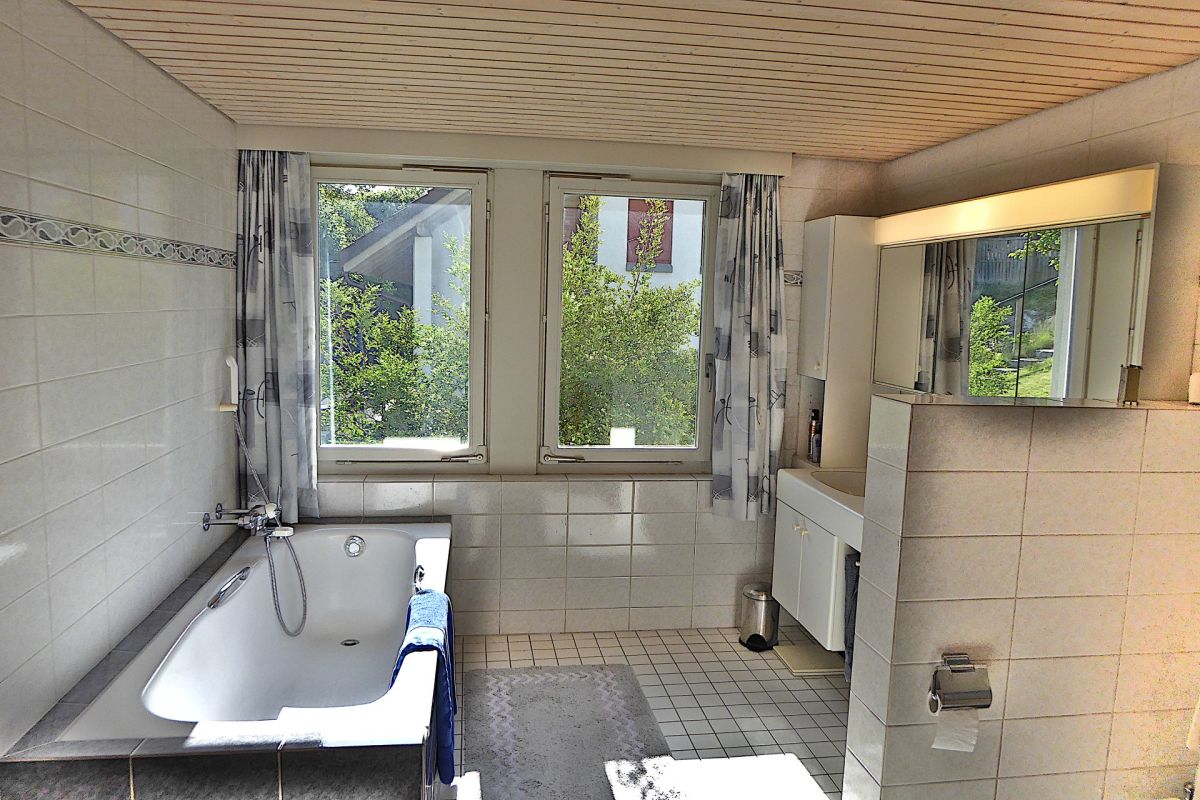 Badezimmer mit Badewanne und Doppelwaschtisch