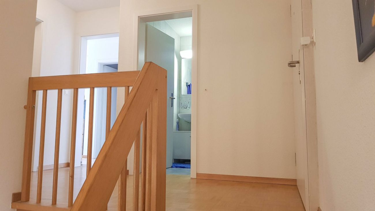 Flur mit Treppenabsperrung und Blick ins Bad