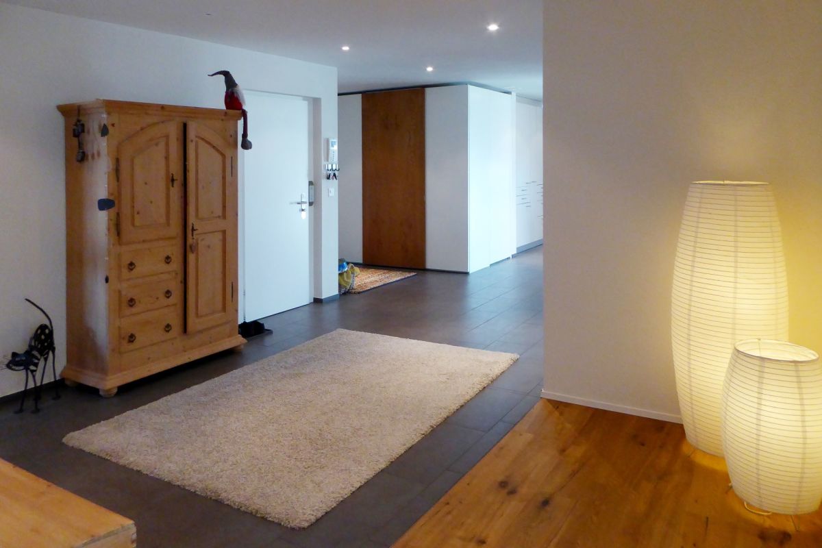 Moderner Flur mit Holzschrank und indirekter Beleuchtung