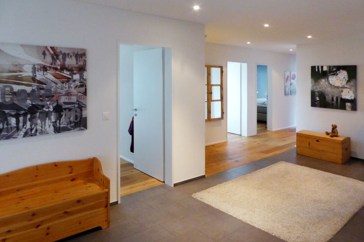 Heller, moderner Flur mit Holzbank und Kunst