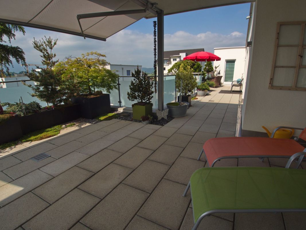 Dachterrasse mit Sitzbereich und Pflanzkübeln