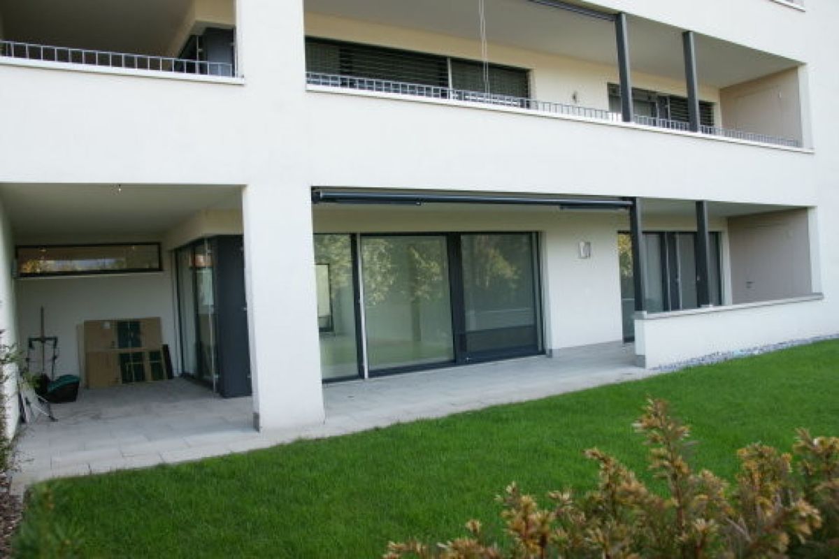 Moderne Wohnhausfassade mit Terrasse und Garten