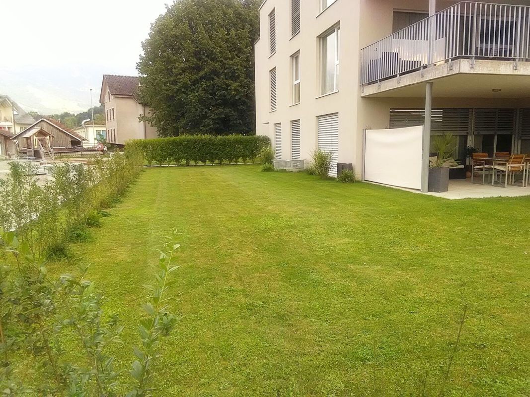 Gepflegter Garten mit Mehrfamilienhaus
