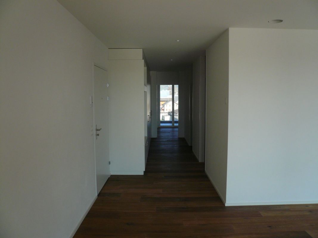 Langer, leerer Flur mit Blick zum Fenster