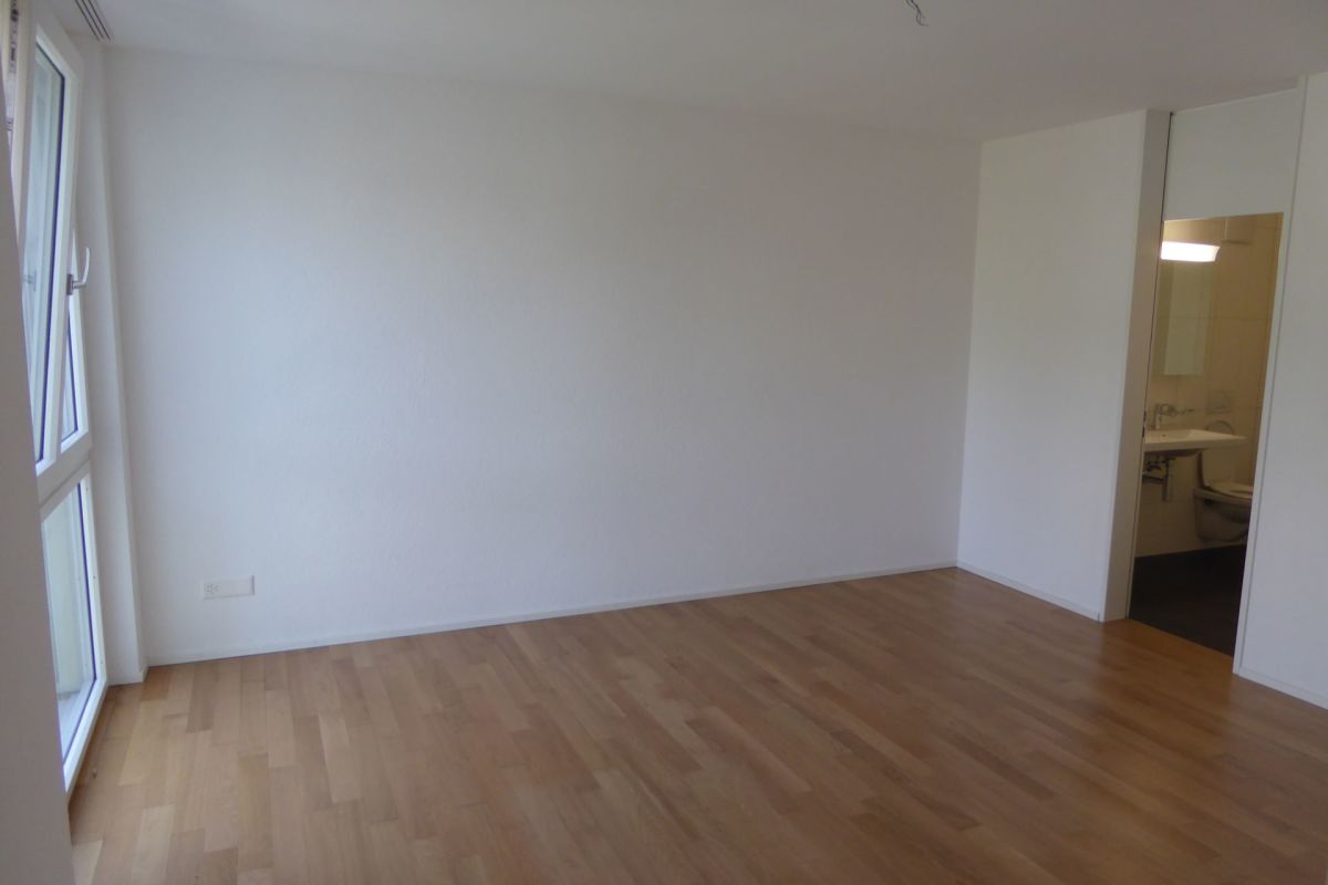 Leerer, heller Raum mit Holzboden
