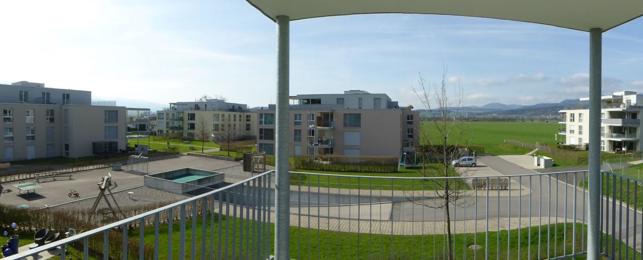 Balkon mit Blick auf Wohnanlage und Grünflächen