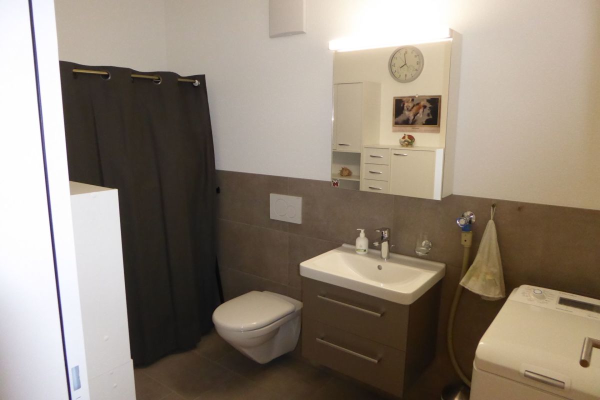 Modernes Badezimmer mit Waschbecken, WC und Waschmaschine