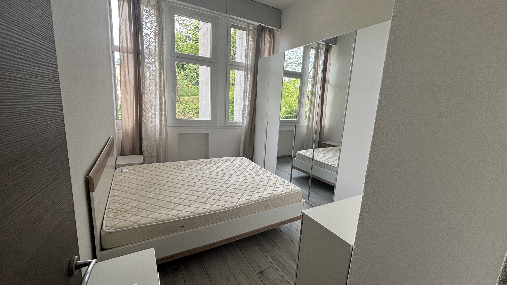 Helles Schlafzimmer mit Bett und Kleiderschrank