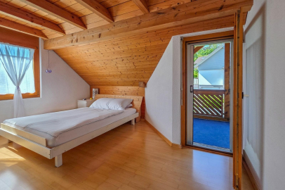 Schlafzimmer mit Holzdecke und Balkonzugang