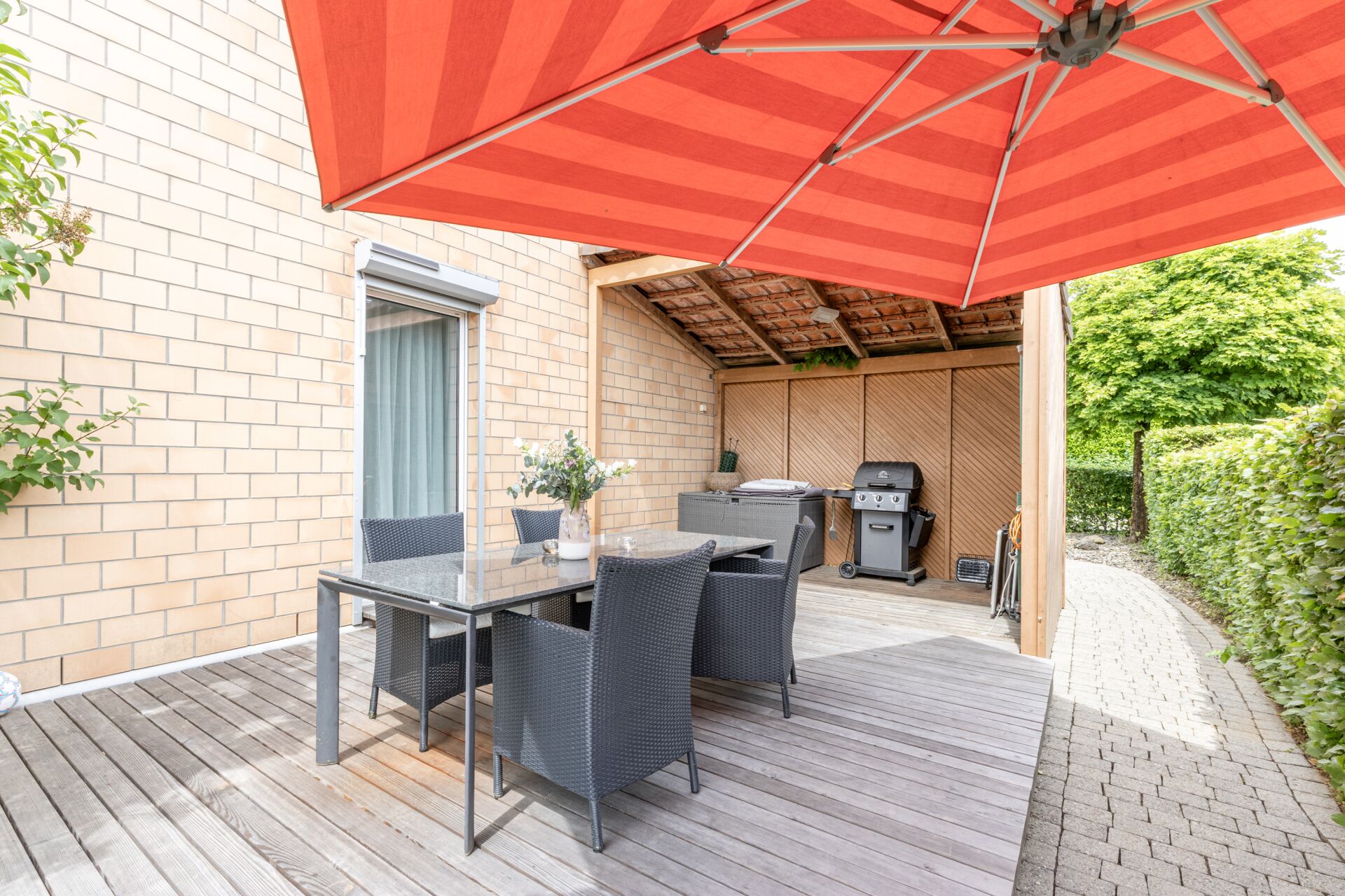 Überdachte Terrasse mit Essbereich und Grill