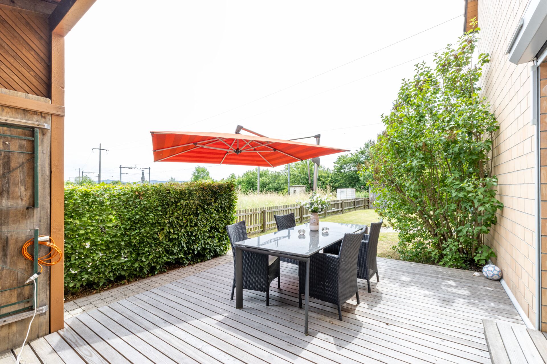 Terrasse mit Esstisch und Sonnenschirm