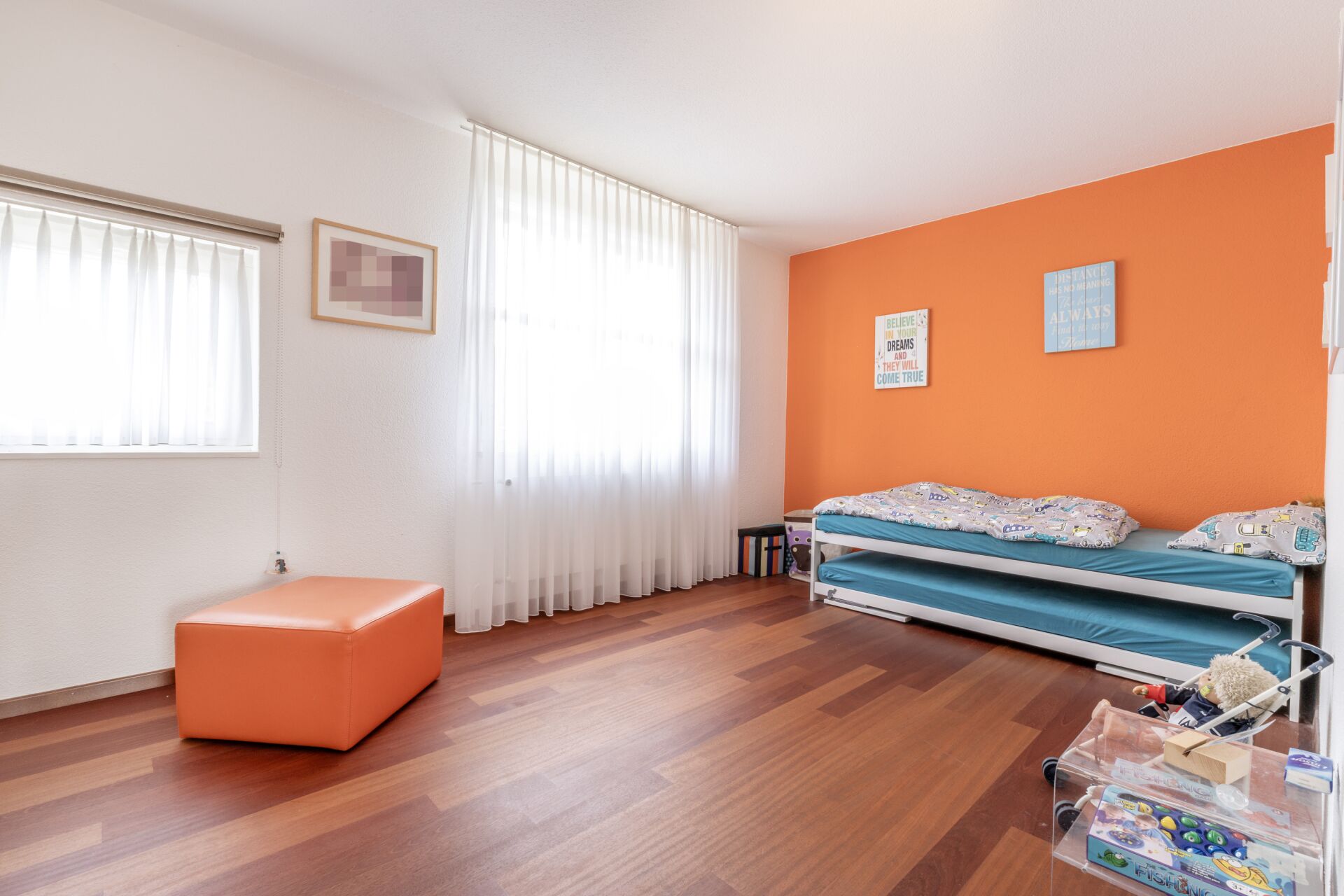 Helles Kinderzimmer mit orangefarbener Akzentwand