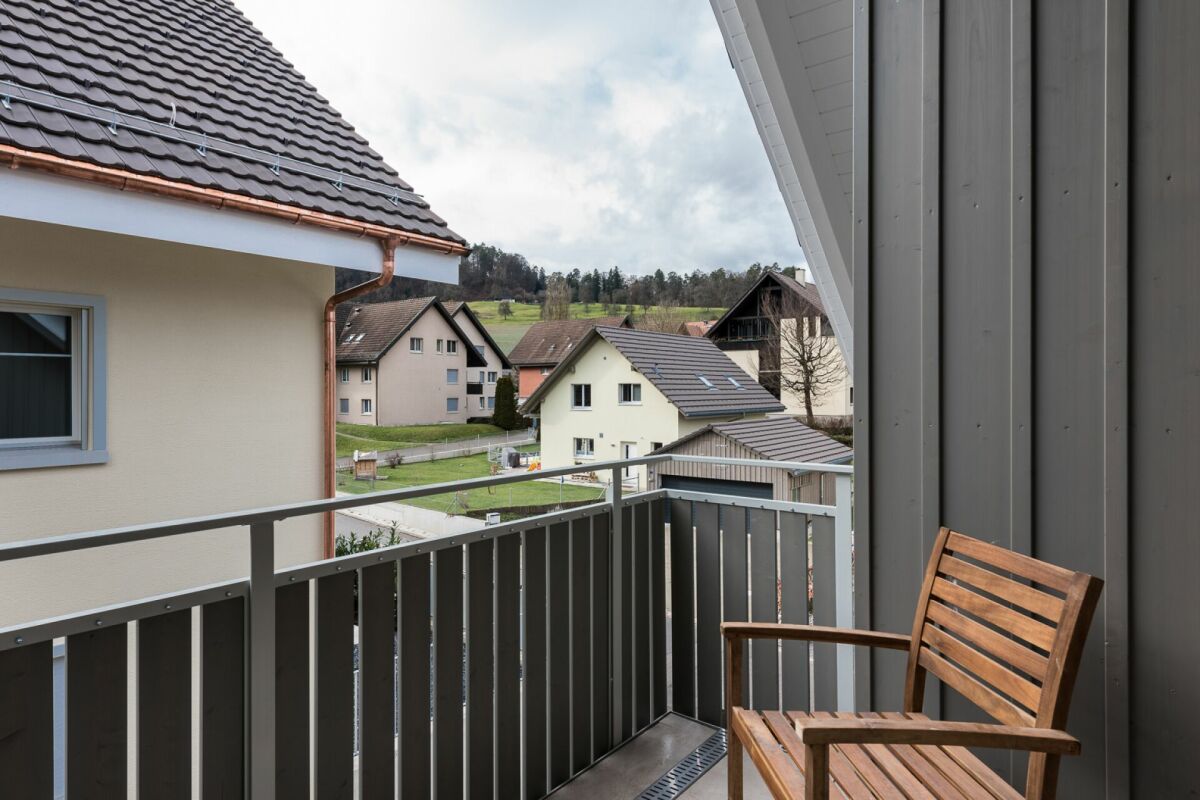 Balkon mit Blick auf Wohnhäuser und Landschaft