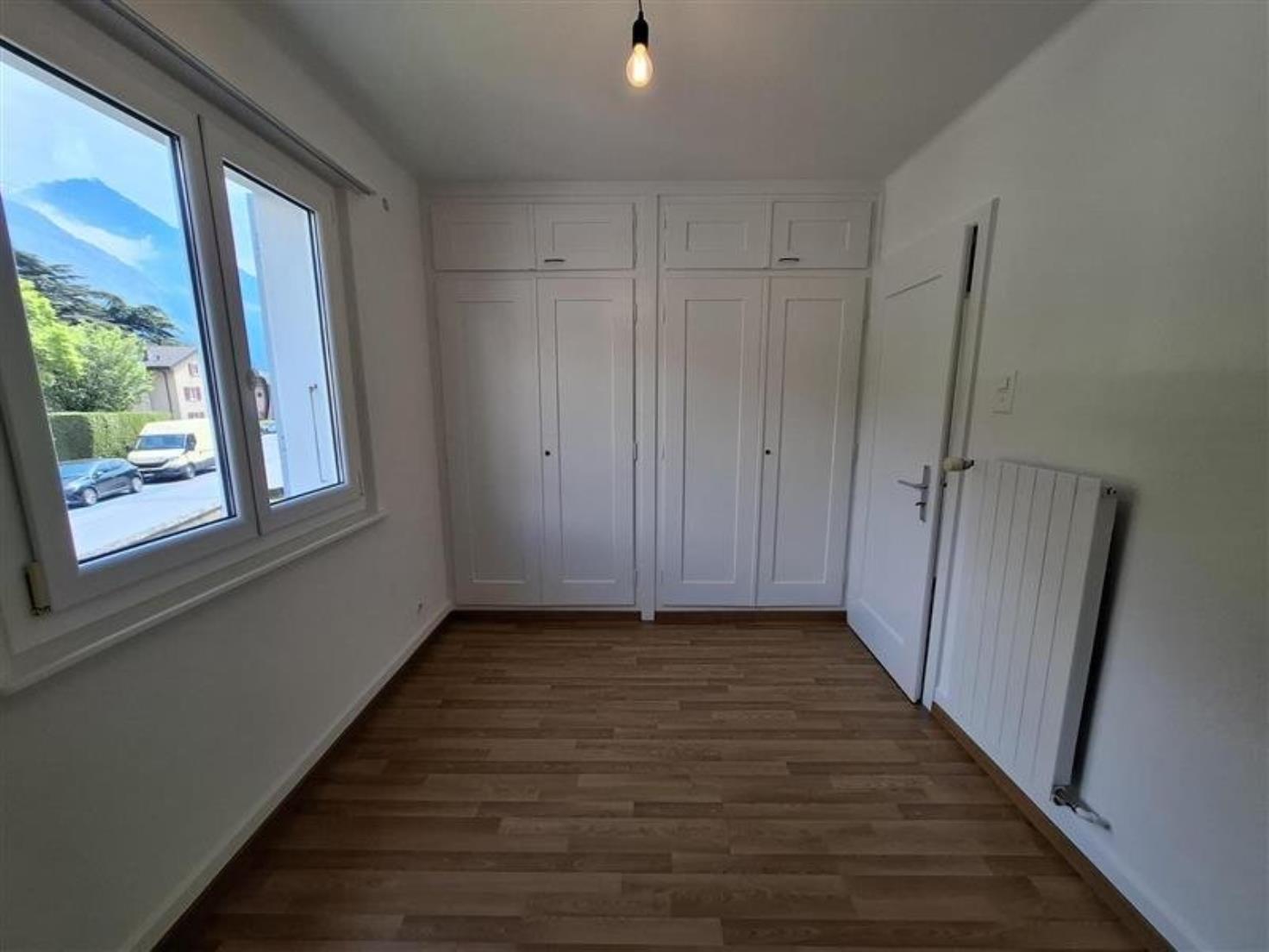 Helles Zimmer mit Einbauschränken und Fensterblick