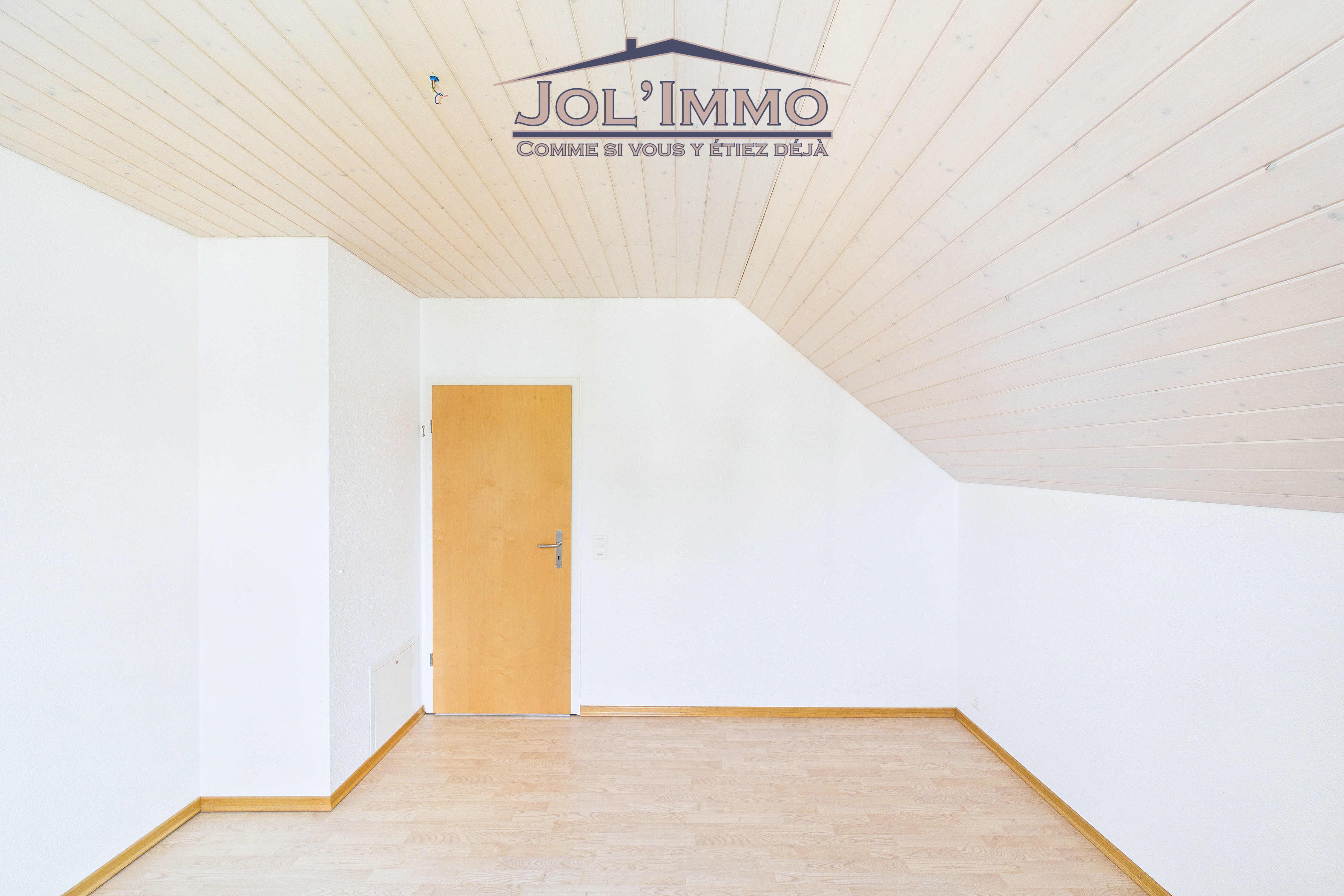 Leerer Dachgeschossraum mit schräger Decke