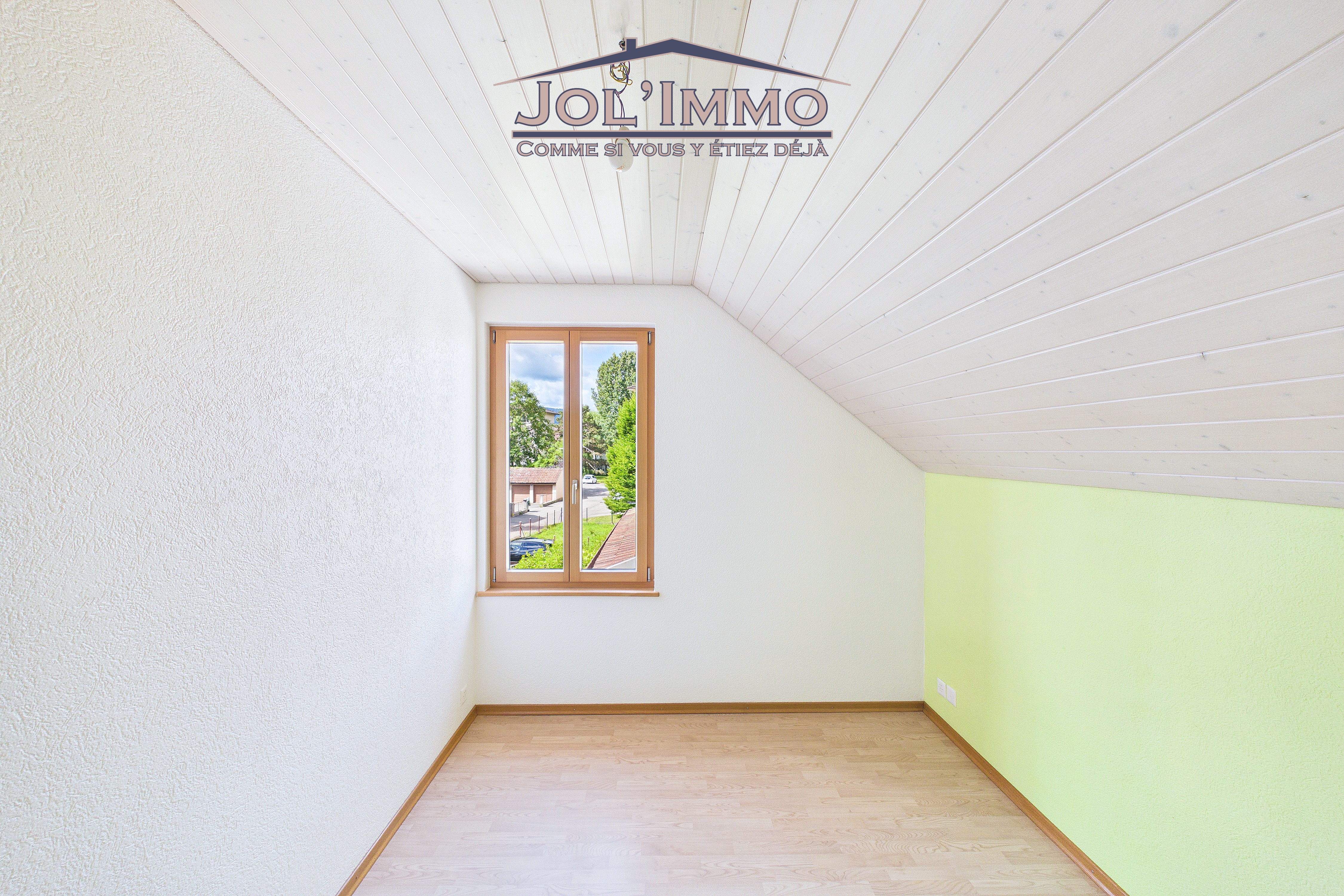 Dachzimmer mit Schrägdecke und Fenster
