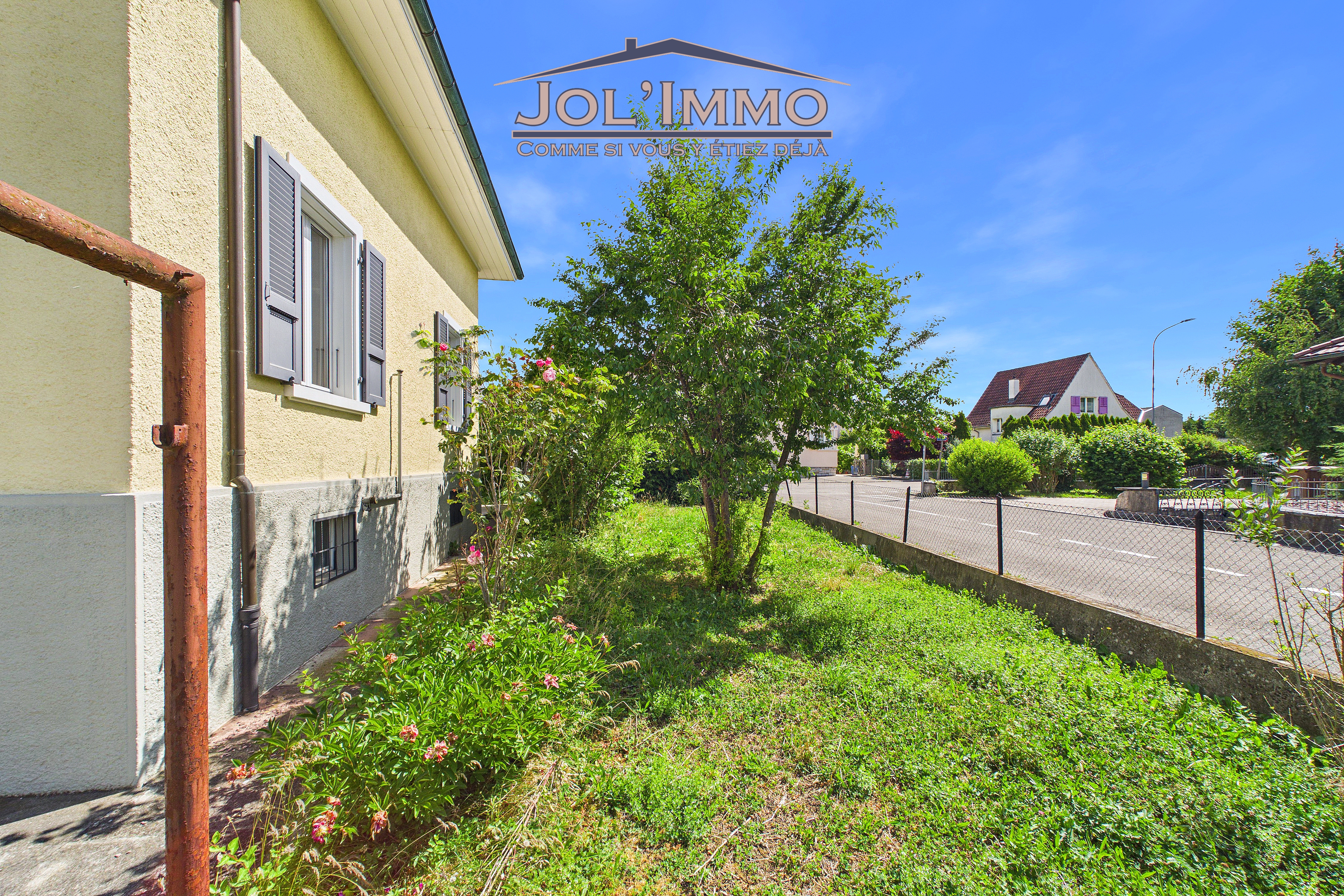 Wohnhaus mit Vorgarten und Straßenansicht
