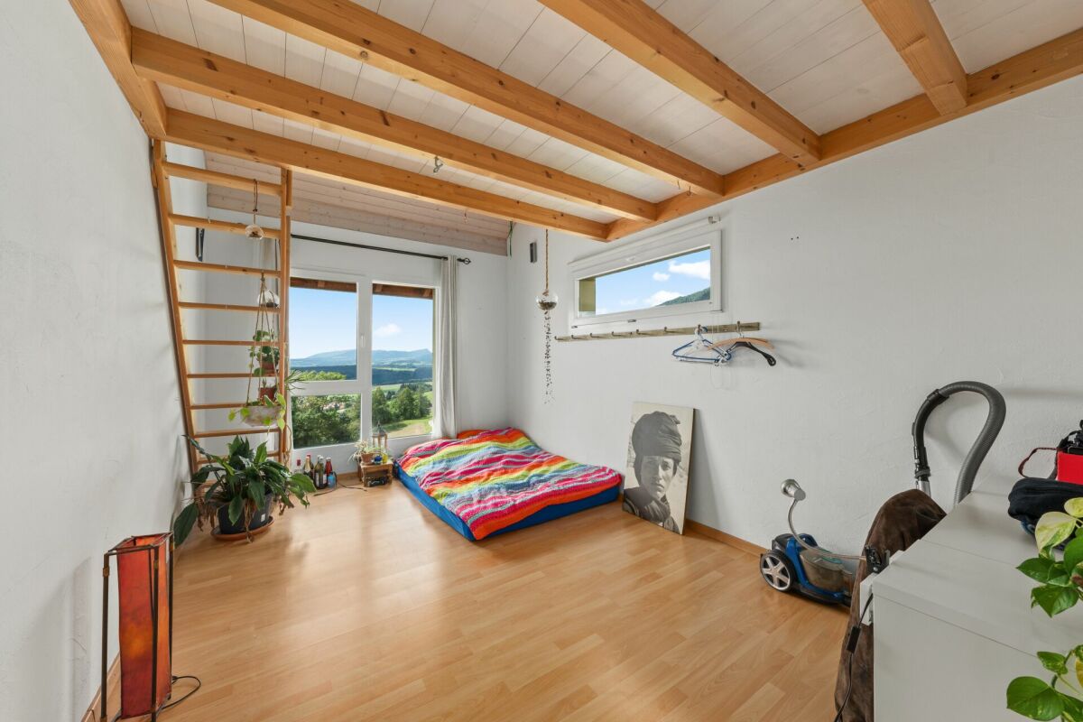 Helles Zimmer mit Holzbalkendecke und Bergblick