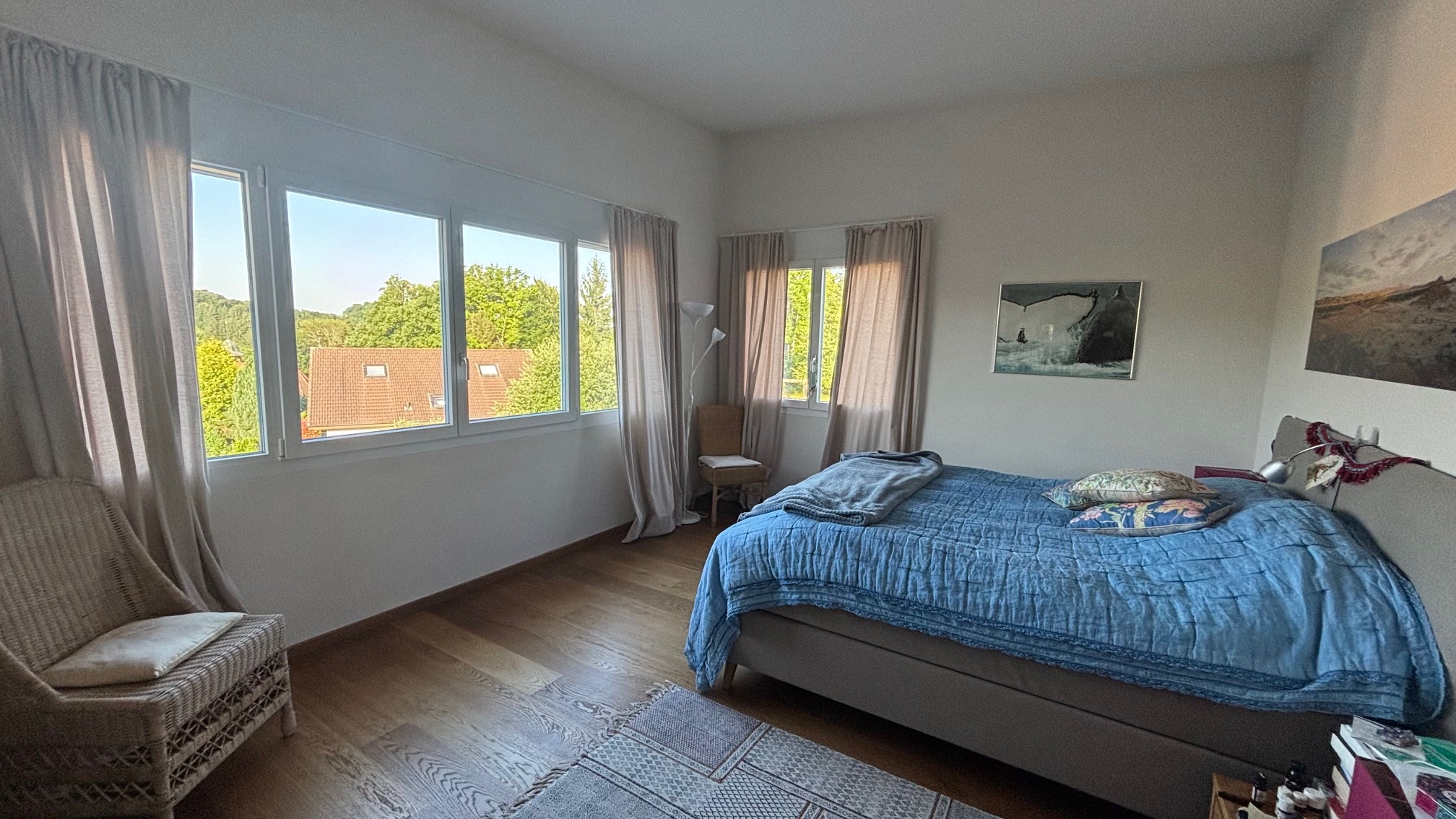 Helles Schlafzimmer mit großen Fenstern und Gartenblick