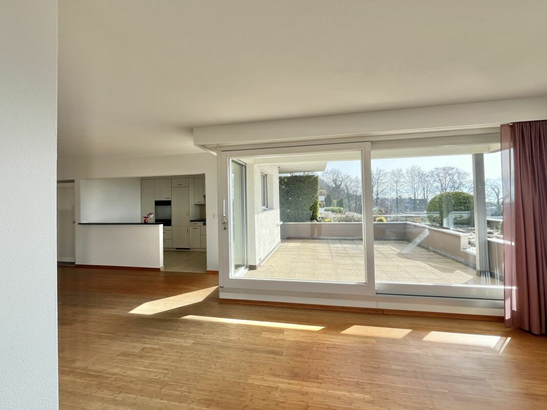 Heller Wohnraum mit großer Glasfront und Zugang zur Terrasse
