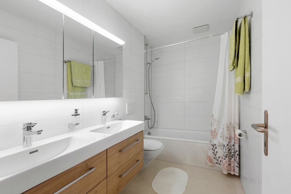 Helles, modernes Badezimmer mit Doppelwaschtisch und Badewanne