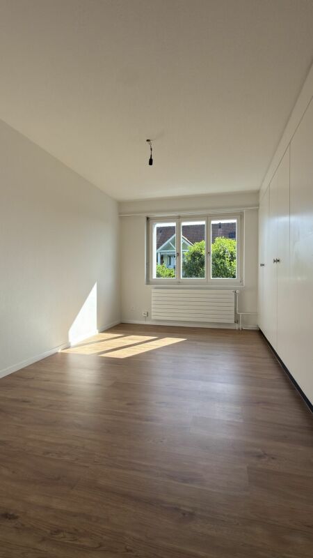 Helles, leeres Zimmer mit Fenster und Einbauschrank