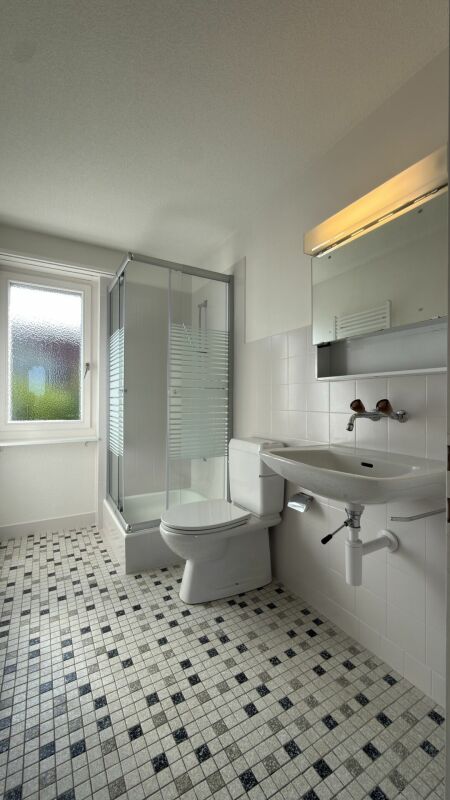 Helles Badezimmer mit Dusche und Waschbecken