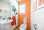 Orangefarbenes Badezimmer mit Dusche und WC